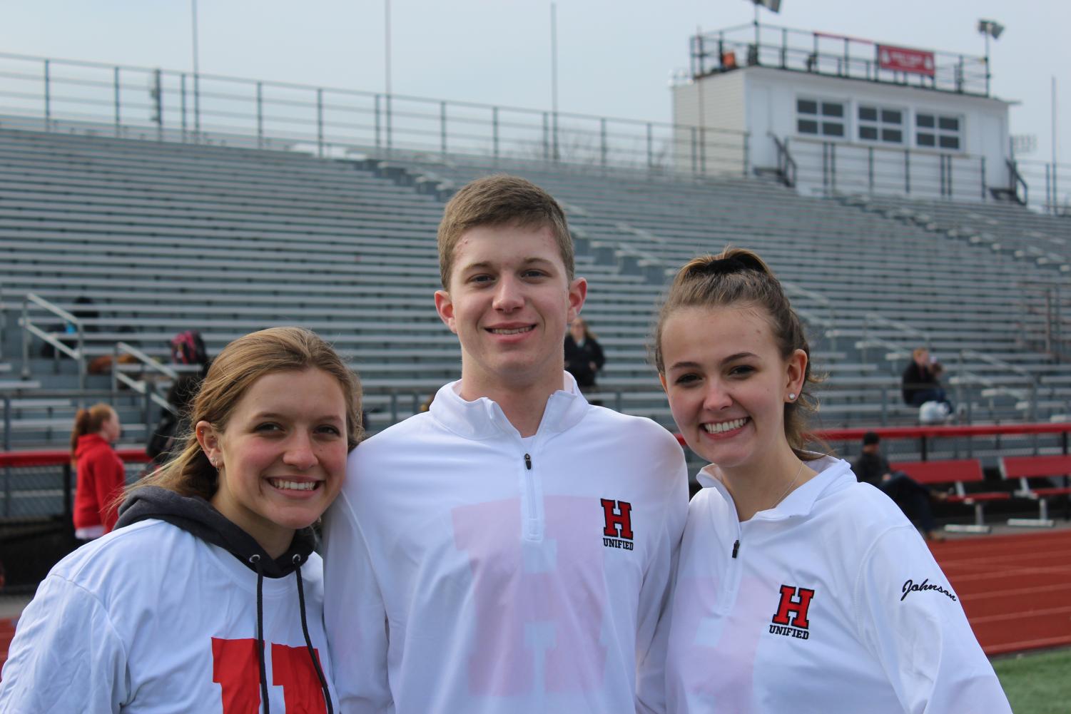 Junior Laine Skamarycz, freshman Mitch Wilson, and junior Zoe Johnson smile at their meet.