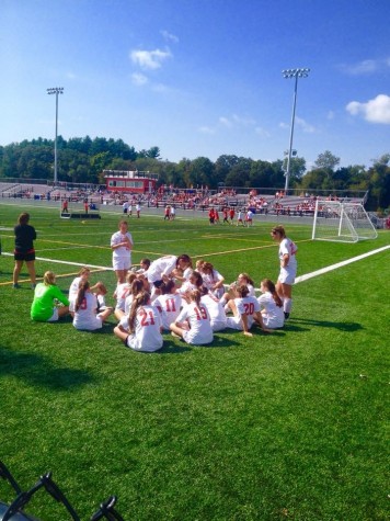 Girls Soccer pre-game team huddle while Best Buddies goes on field. 