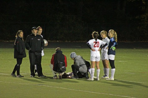 Emma Burleigh sits on the field injured. 