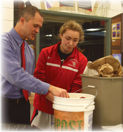 Vice Principal Richard Swanson helps a student Slash the Trash, a major component of Hinghams efforts to be a green school.