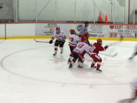 Players fight for the puck after a face off. 