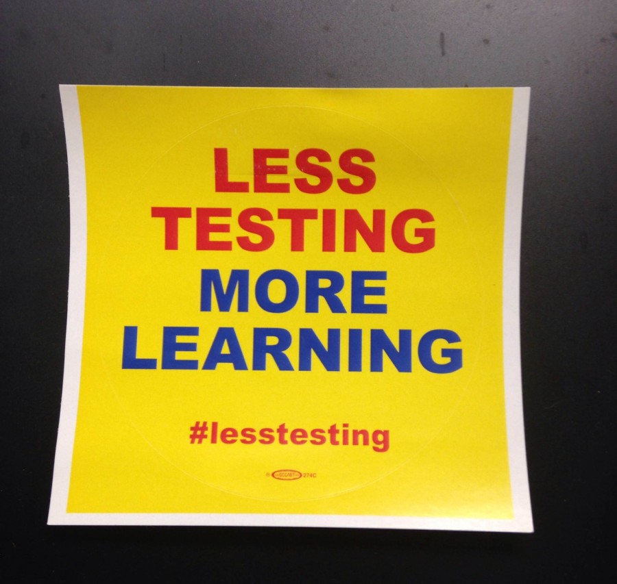 Teachers wear less testing more learning stickers to show support for a teaching philosophy with less standardized testing. 