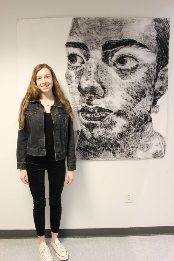 Senior Olivia Reavey poses next to her artwork. 