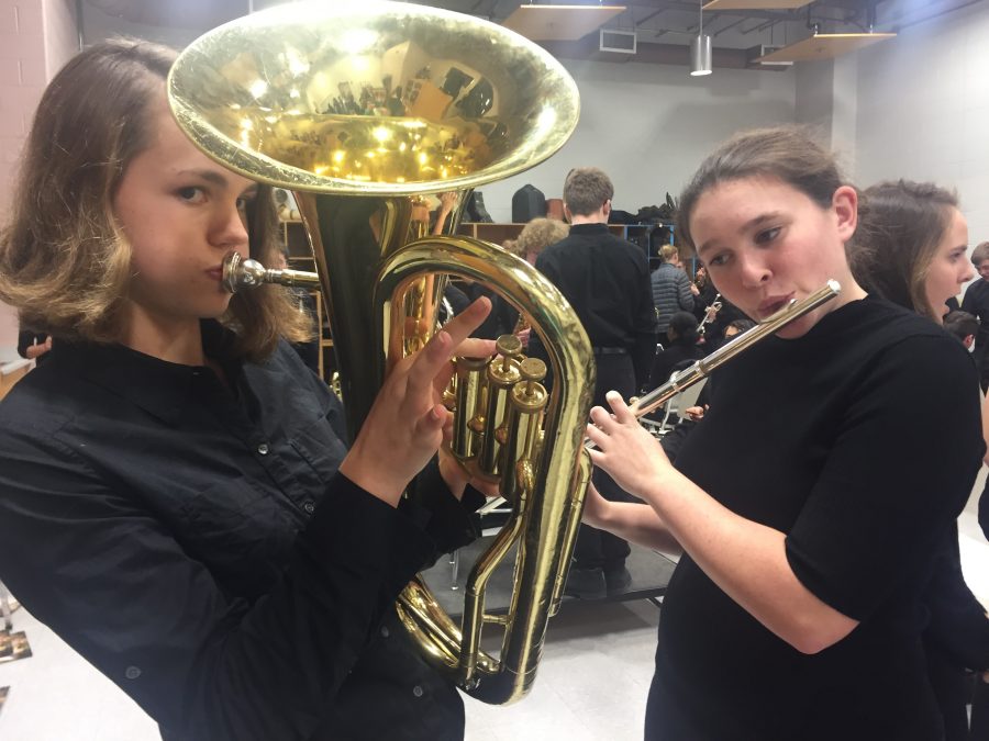 Freshmen Adeline Van Buskirk and Taylor Moynihan pose with their instruments in the band room before the concert

