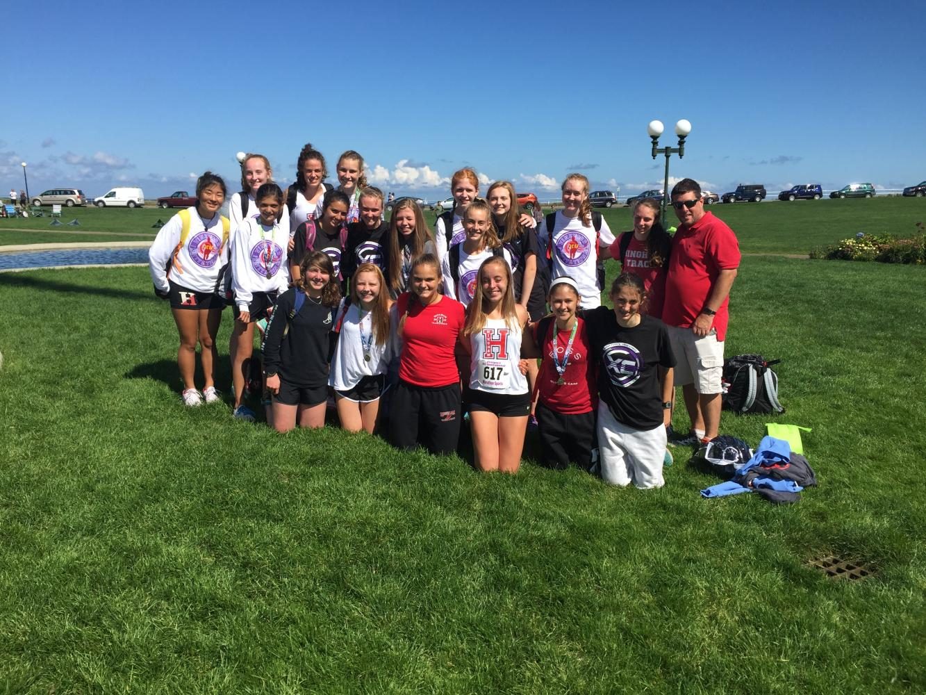 The Hingham Girls' Cross Country team at Oak Bluffs pose by the water, right after finishing their races.