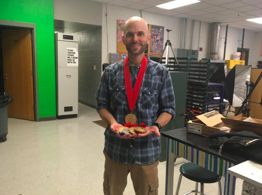 Graphic Design teacher Mr. Eshow with past year medals awarded to Hingham High School students at the national awards.