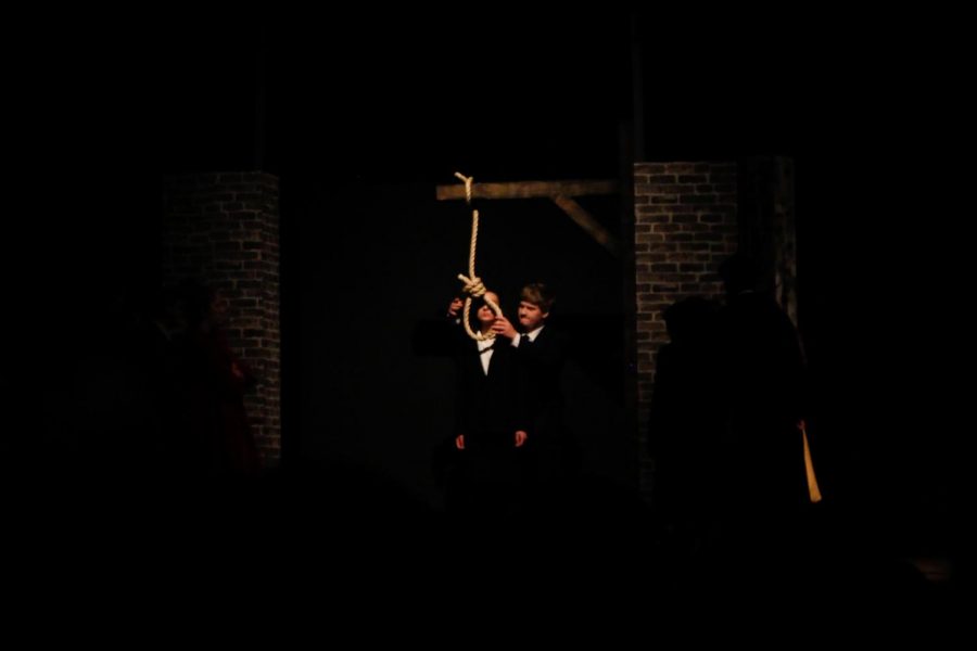 A guard (played by Steven Reis) prepares to hang Greta (played by Shea Kushnir) for her crimes against humanity.