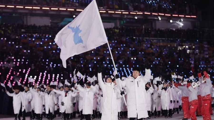 North+Korean+and+South+Korean+athletes+march+into+the+Olympic+Stadium+in+Pyeongchang+under+the+same+flag%2C+with+both+a+North+Korean+and+South+Korean+athlete+holding+the+flag.+Photo+via+CNN