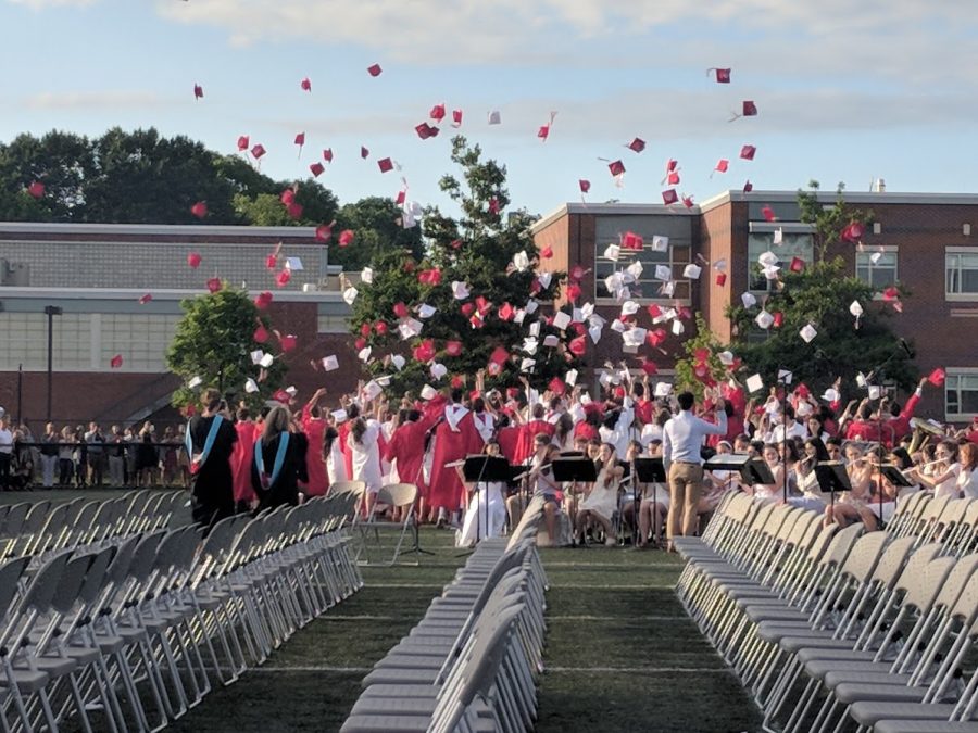 The members of the graduating class of 2018 throw their caps into their air in celebration.
