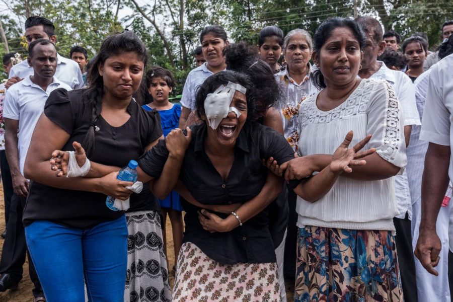 Mourners of the victims of the attacks in Sri Lanka break down while attending a mass burial in Negombo. (Adam Dean for the New York Times)
