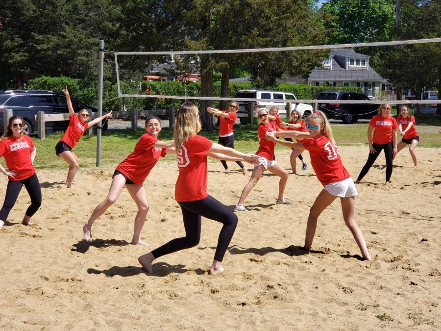 A group of senior girls pose before beginning a game of volleyball. 