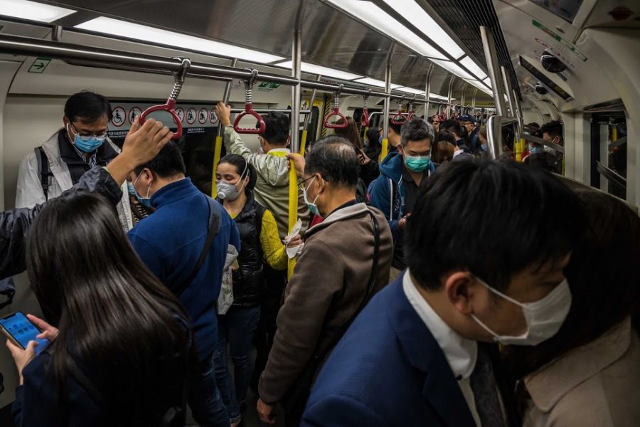 A Chinese subway filled packed to the brim with masked passengers.