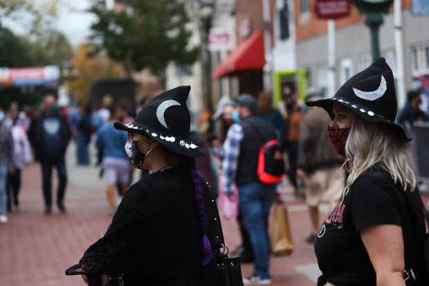 Salem, MA: October 16, 2020: Visitors wear masks as they walk along the Essex Street Pedestrian Mall in Salem, Massachusetts. 