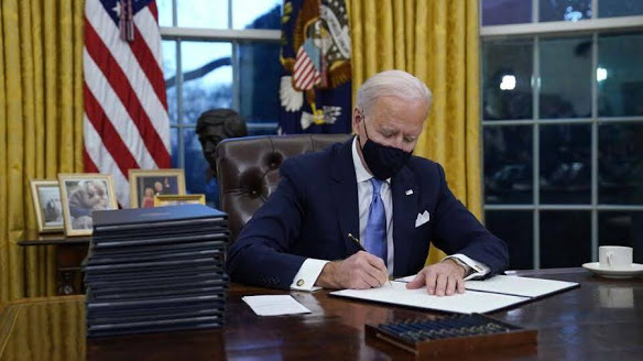 President Biden signing executive orders on his first day in office. 