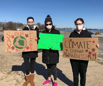 (From left to right): Hingham residents Emma Kahn, Jana Kahn, and Helen Kahn participating in a Hingham Net Zero climate standout on March 20.