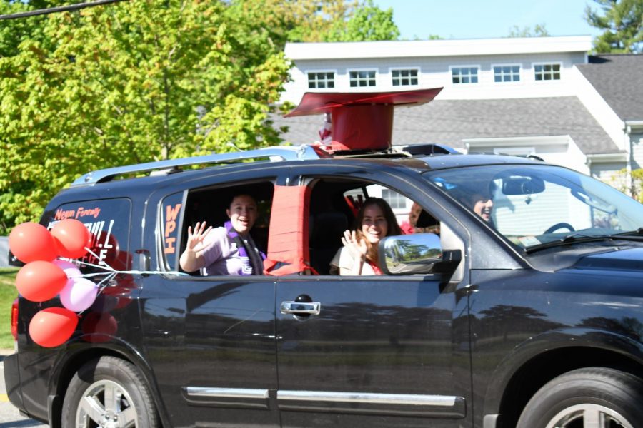 Megan Fennelly, Olivia Spielberger, and Brian Fennelly wave from their car as they drive down Main Street.