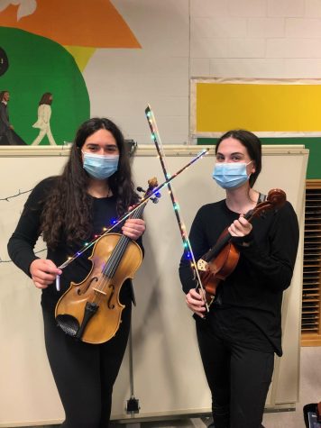 Seniors Sarah Bryden and Charlotte Andrews show their decorated light up bows for the combined band and orchestra finale.