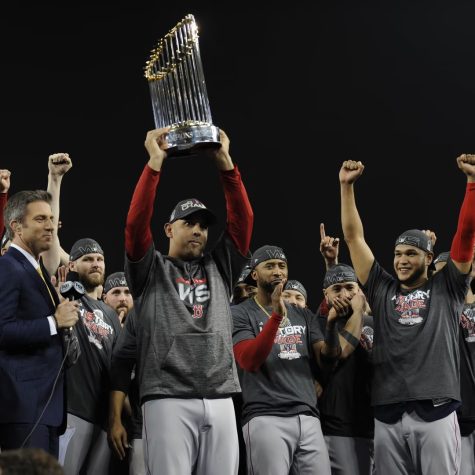 Alex Cora holds up the Commissioners Trophy after the Red Soxs win against the LA Dodgers in the 2018 World Series.