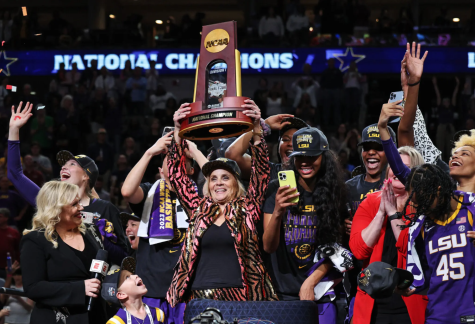 Coach Kim Mulkey lifts the trophy as she celebrates with LSU

