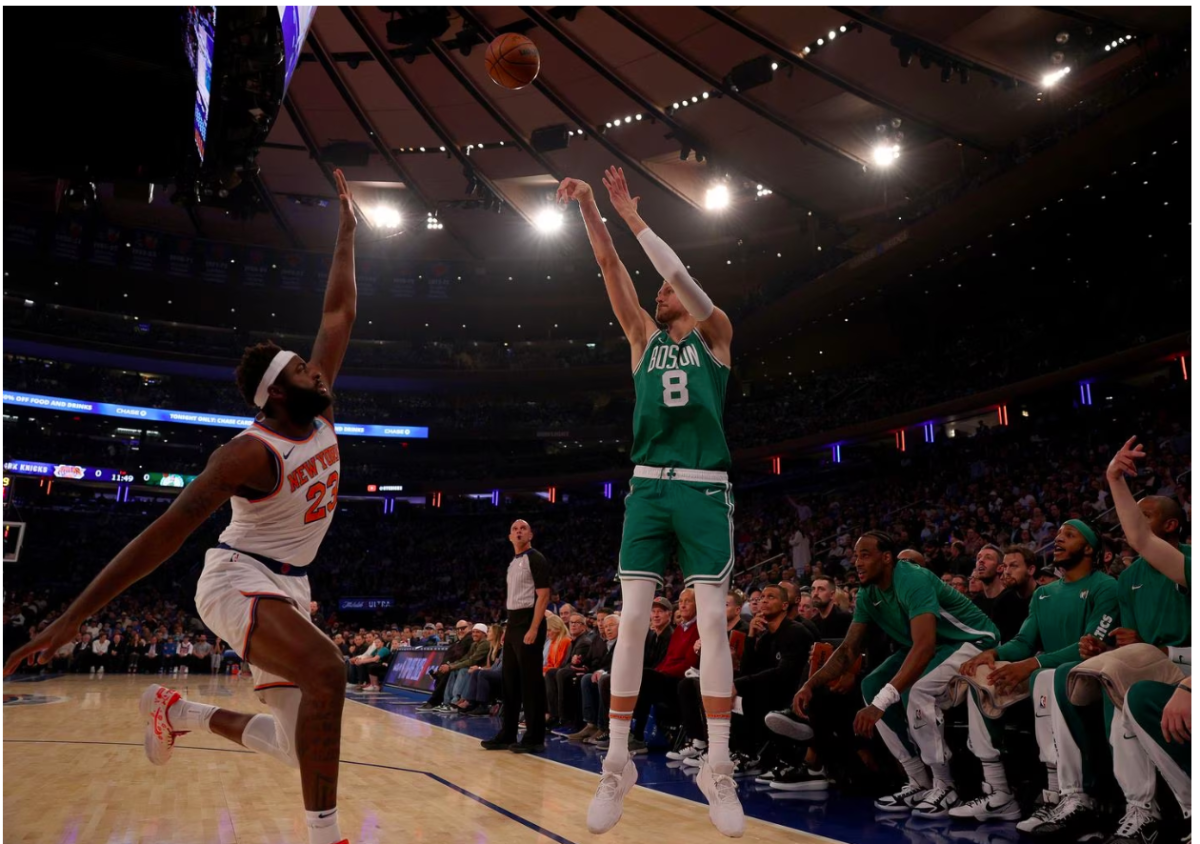 Kristaps Porzingis shoots a three over Knicks player Mitchell Robinson. Credit: ELSA/Getty