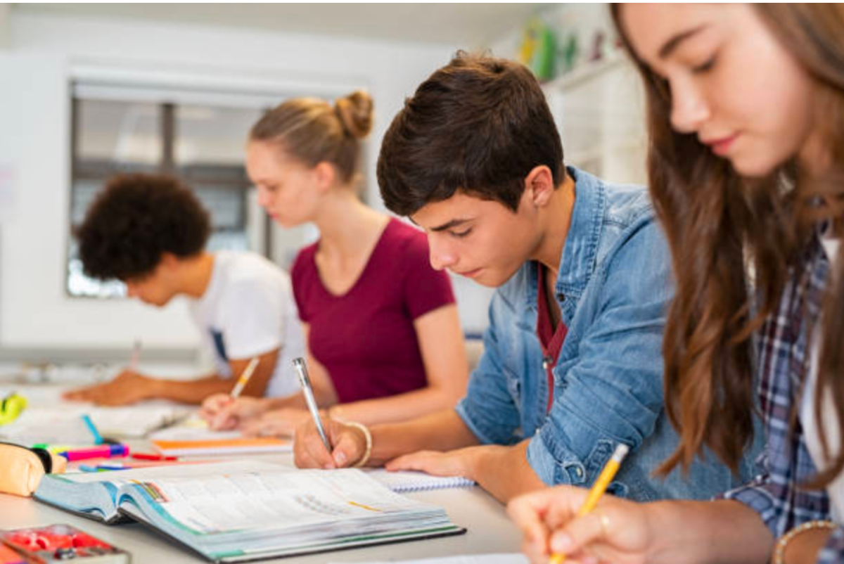 Teenagers doing school work in a classroom. https://www.istockphoto.com/photos/teenagers-studying 