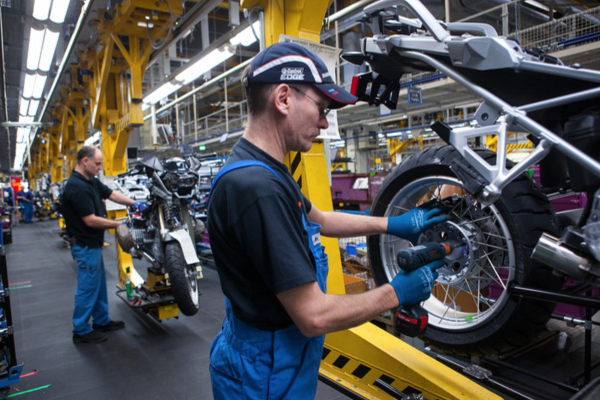 Assembly line laborers working at a BMW factory in Berlin. Photo by Bloomberg News
