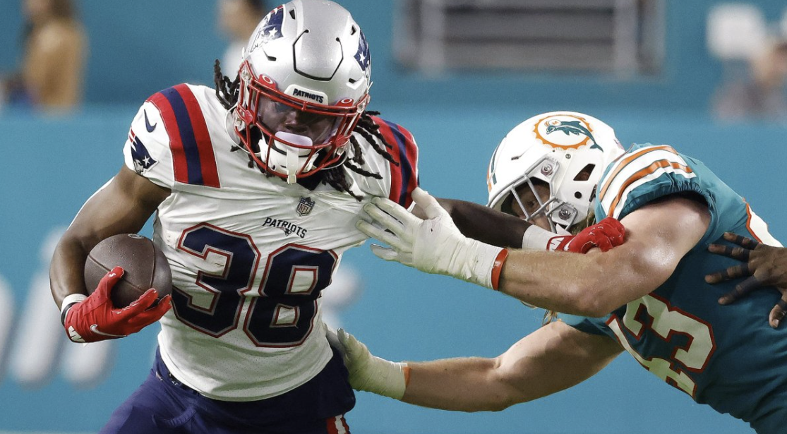 Rhamondre Stevenson breaking a tackle in the Patriots vs. Dolphins game in 2022.