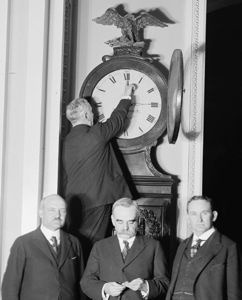 A clock being turned forward on the first Daylight Savings Time in 1918 by Senator Charles Higgins. (George W. Harris).
