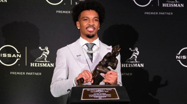 LSU quarterback Jayden Daniels poses with the Heisman trophy after winning the award in 2023 (Brian Ciancio/AP). 
