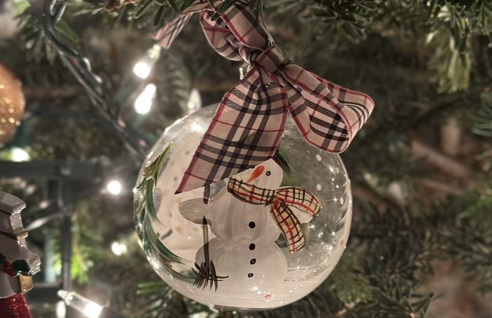  A snowman ornament hangs from a Christmas tree 