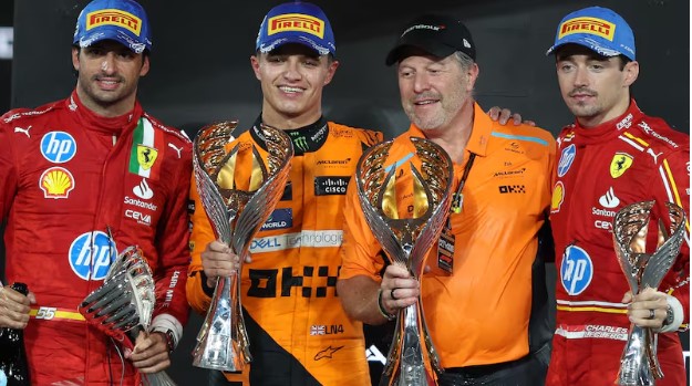 Drivers and team principal, from left to right, Carlos Sainz (Ferrari), Lando Norris (McLaren), Zak Brown (McLaren), and Charles Leclerc (Ferrari), pose for a picture on the podium of Abu Dhabi 2024, Chris Whiteoak/The National
