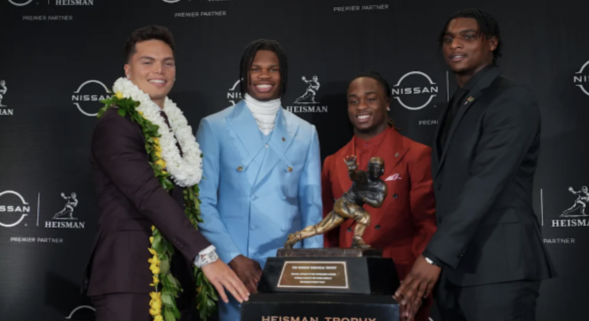 From left to right, Dillon Gabriel (Quarterback, Oregon), Travis Hunter (Wide Receiver/ Cornerback, Colorado), Ashton Jeanty (Running Back, Boise State), Cameron Ward (Quarterback, Miami), all finalists for the Heisman posing in front of the trophy.