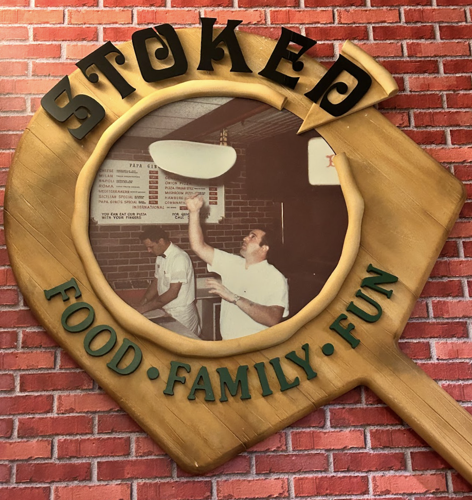 An art piece hanging in an alcove of Stoked shares a snapshot of the chain’s history and slogan; “Food, Family, Fun.”