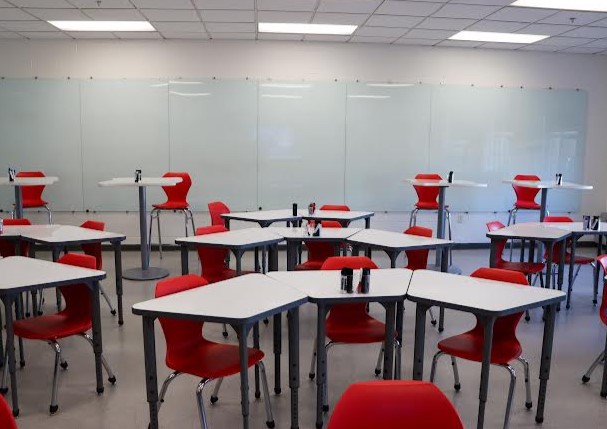 Rows of new whiteboard tables, chairs, and hightops sit in front of a shining new glass whiteboard wall. Taken by Gus Doggett
