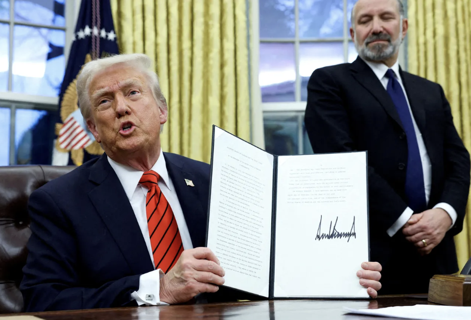 President Donald Trump holds a signed executive order imposing 25% tariffs on aluminum imports.