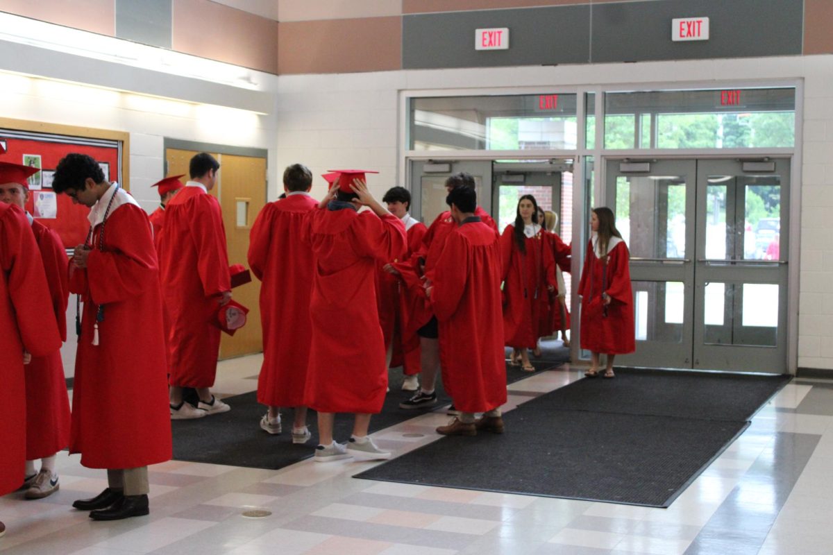 The HHS Class of 2025 gathers in the main lobby, waiting for the ceremony to begin. 