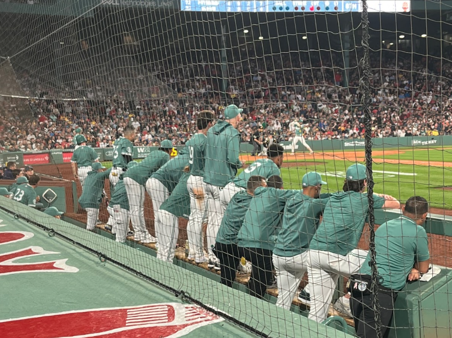 The Red Sox Bench looks on attentively as Carlos Narvaez digs into the batters box
