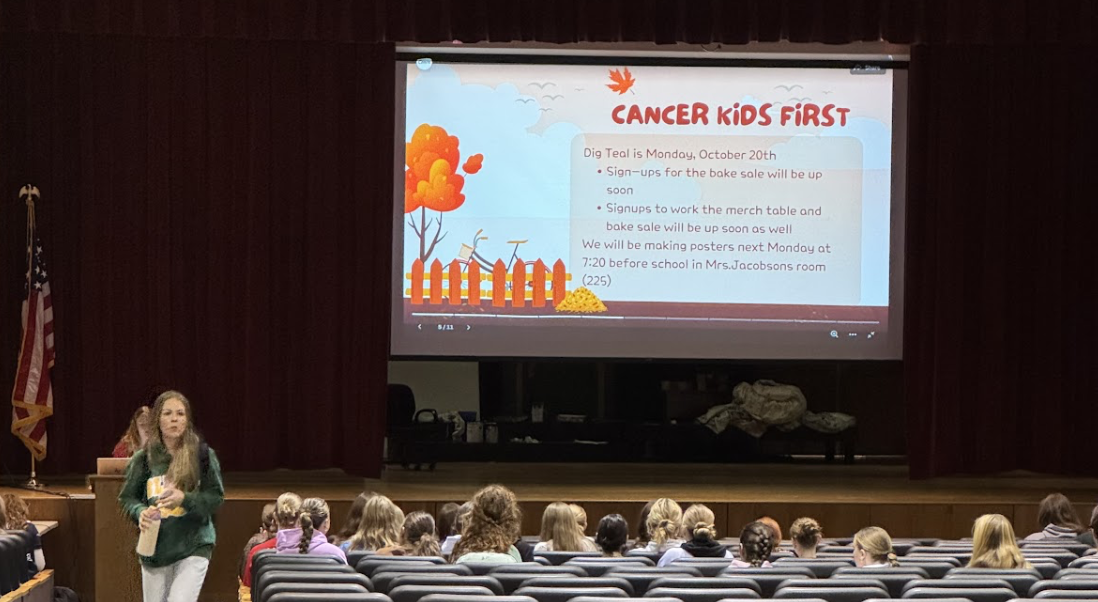 Students listen to club executives speak at a Service Club meeting. 