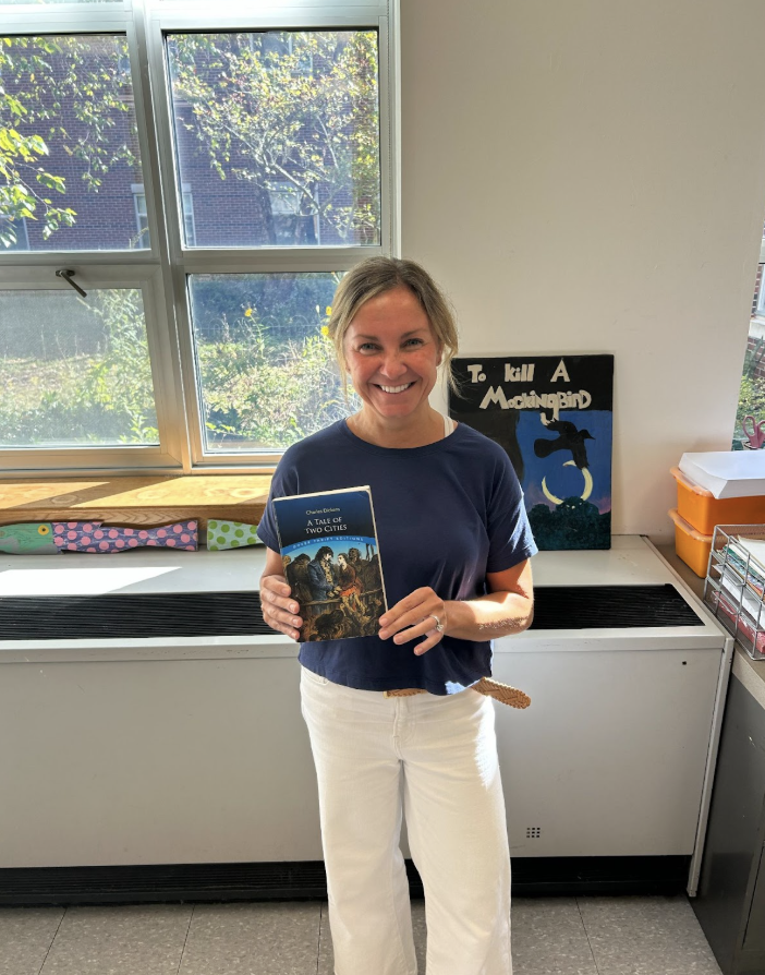Mrs. Allen holding her favorite book, "A Tale Of Two Cities" by Charles Dickens.
