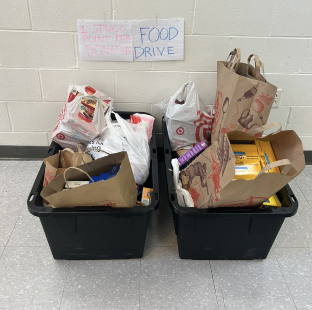 Students donate in the donation bins in the front lobby for Hingham High School’s Food Drive, receiving Student Council points. 

