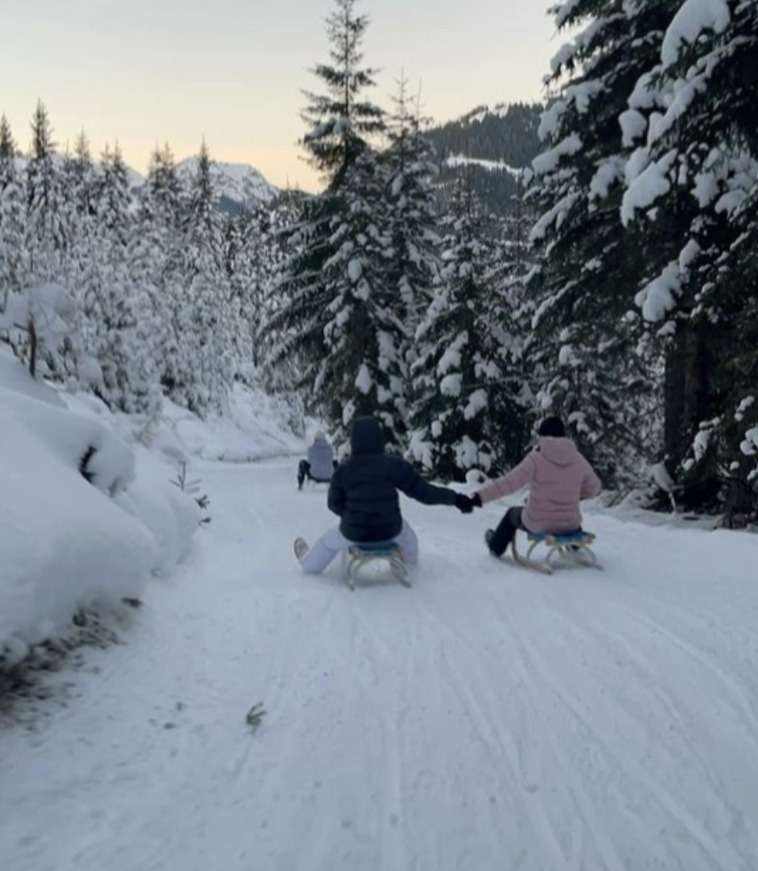 Two friends go sledding in the winter.
