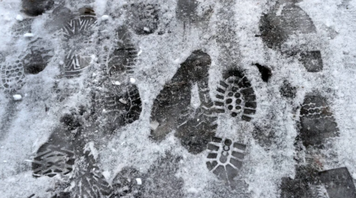 Footprints scatter the snow on a pathway in Boston Public Garden.