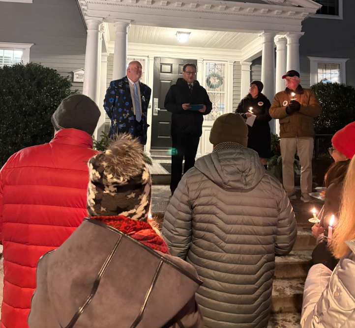 Cantor Steven Weiss (left) and Rabbi Eric Berk (middle) lead a candlelight vigil during the menorah lighting ceremony.