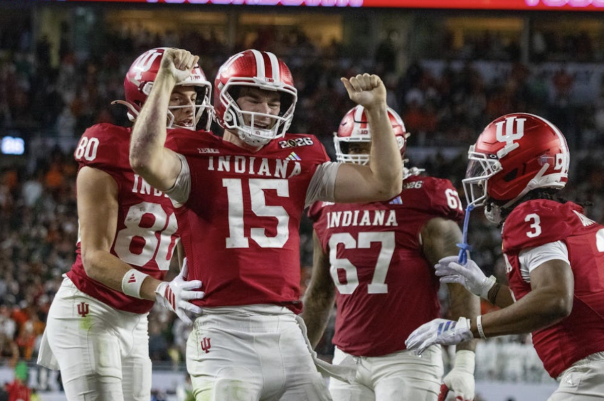 Quarterback Fernando Mendoza (#15) celebrates surrounded by teammates after an exciting touchdown during the 2026 CFP National Championship.