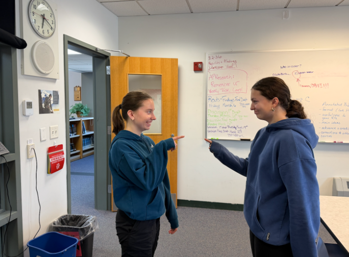 Grace Whiting (left) and Maggie Pierce (right) debate the answer to a trivia question. 