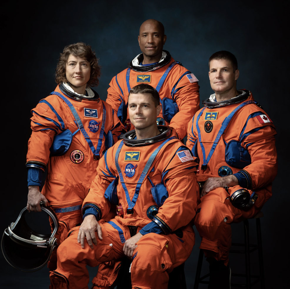The crew of Artemis II sits left to right: Christina Koch, Victor Glover, Reid Wisemann (seated), and Jeremy Hansen. 