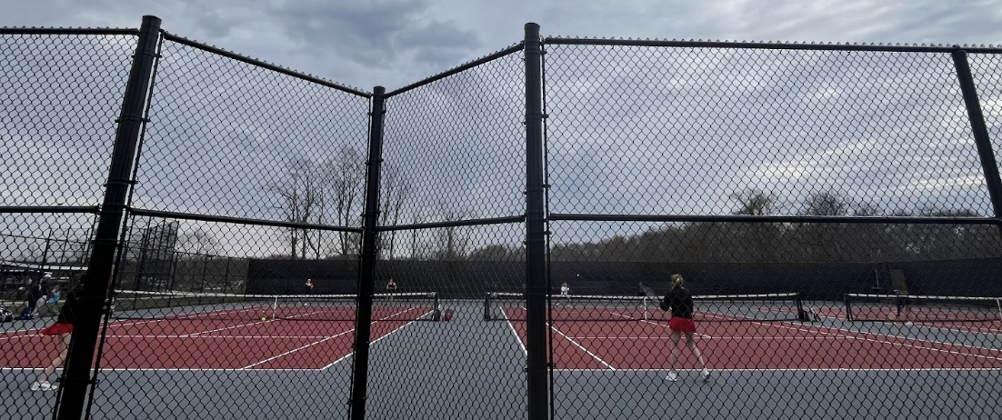 The doubles courts rally and play as the fight for points intensifies at the match on Monday.