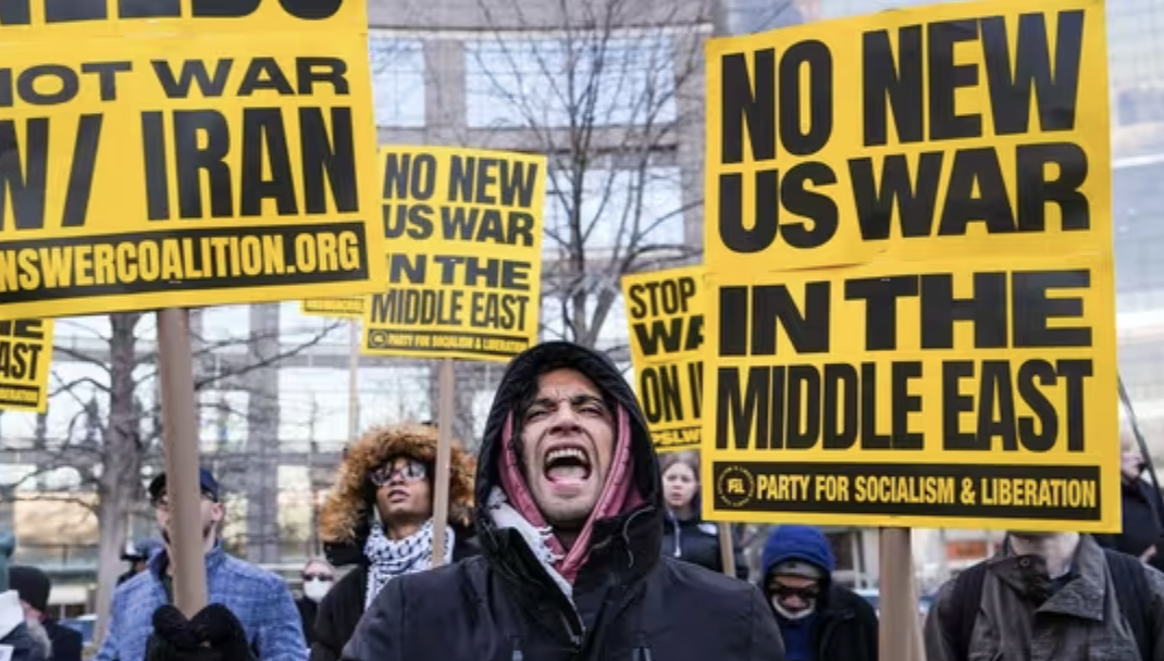 Citizens in the United States chant and use signs to protest against starting a war in Iran.