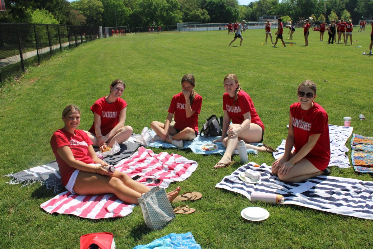Seniors sprawled out on towels, enjoying the sun. 