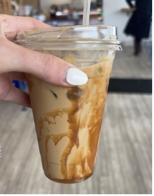 A Hingham local holding up her favorite iced caramel latte from Brewed Awakenings.